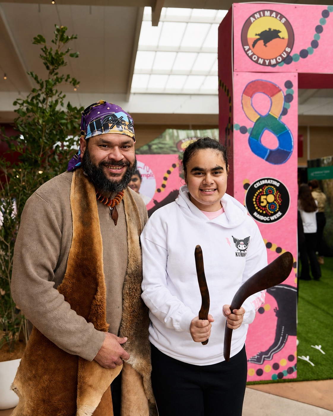 Petiola Wilson and a young woman holding cultural objects